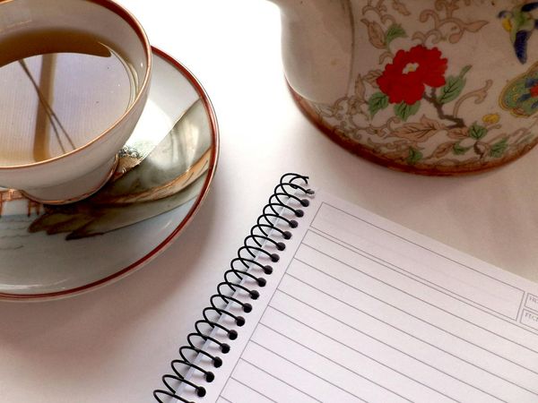 A calm morning scene with a cup of tea and a notebook.